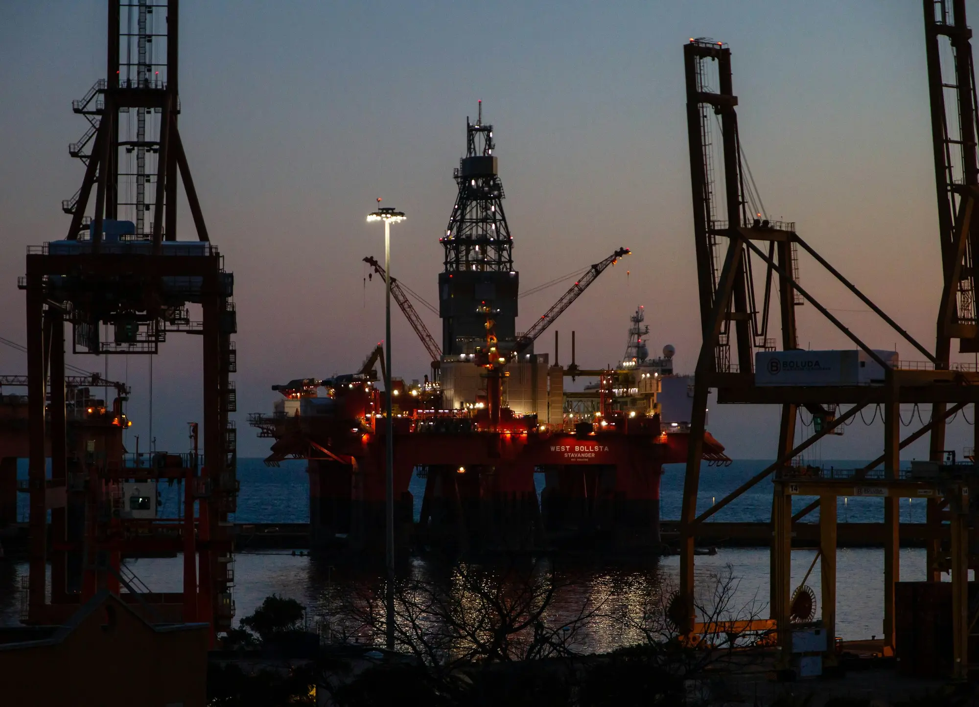 Unidade offshore atracada em porto ao entardecer